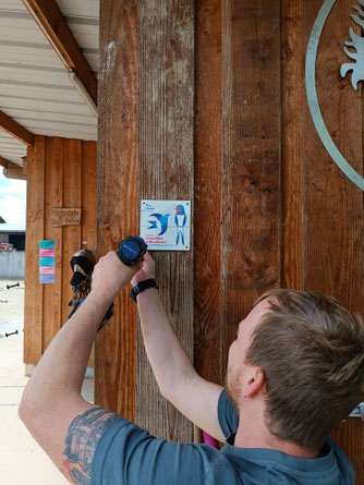 Schwalbenfreund Patrick Ehrhardt bringt die Plakette "Schwalbenfreundliches Haus" am Pferdestall an