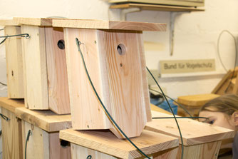 Mehrere selbstgebaute Nistkästen aus Holz für Meisen