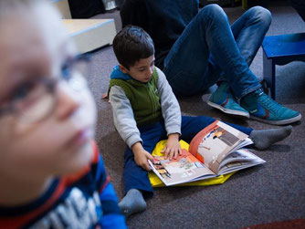 Ein Junge liest in der Kinderbibliothek der Zentralbibliothek in Hamburg in einem Buch. Foto: Maja Hitij