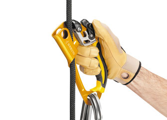 Eine Hand bedient eine gelbe Petzl ASCENSION  Handsteigklemme, welche an einem schwarzen Seil fixiert ist.