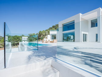 Modern swimming pool landscape with Bali beds and palm trees in Ibiza