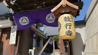 教行寺前の油阪通りから山門を見上げた様子。