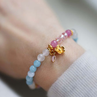 Modernes buntes Perlenarmband aus Edelsteinen in pink und blau mit Blumen Anhänger in Gold