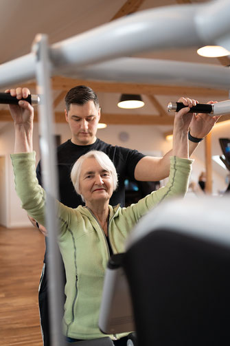 Mitarbeiterfoto eines Trainers mit älterer Kundin beim Gerätetraining in Dinslaken, fotografiert von Olaf Spöllmink
