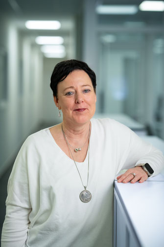 Businessportrait einer Mitarbeiterin im weißen Pullover – fotografiert in den Räumen von IMT Ruhrgebiet durch Olaf Spöllmink