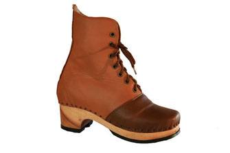sabots suédois relooké en bottines pour femme sur semelle de bois et talon haut. C'est une véritable chaussure de ville, avec une tige en cuir de couleur camel et l'empeigne en marron foncé pour le contraste. ce modèle est réalisé sur mesure