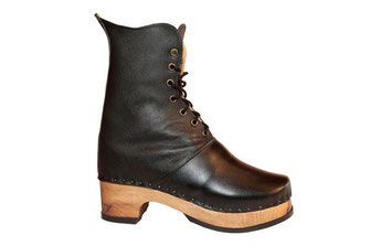 sabots suédois relooké en bottines pour femme sur semelle de bois en noyer et talon carré de 5 centimètres de hauteur. C'est une véritable chaussure de ville, avec une tige élancée et chic, en cuir noir.