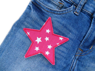 pinker Stern Aufnäher ist auf eine Jeanshose als Flicken aufgebügelt