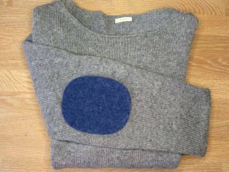 große dunkelblaue Ellenbogen Flicken aus Wolle reparieren einen grauen Wollpullover