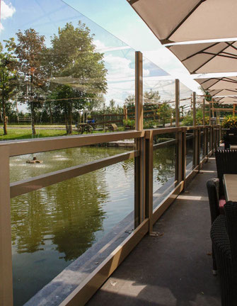 Terrasse am Wasser mit transparenten Windschutzwänden