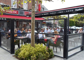 Höhenverstellbarer Windschutz Modell Athen auf einer voll besetzten Restaurant-Terrasse in der Stadt