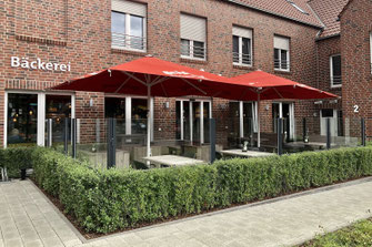 Windschutz-System für Bäckerei, elegante Glasabtrennung kombiniert mit natürlicher Hecke für Terrassen