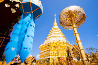 A golden temple with a blue lantern in the foreground in Chiang Mai.