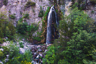 Frau steht am Grunas Wasserfall in der Nähe des albanischen Bergdorfes Theth.