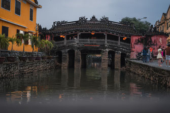 Eine hölzerne Brücke führt über den kleinen Fluss in der Altstadt von Hoi An.