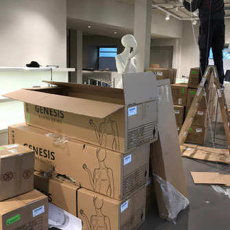 Installation in einem Kleidergeschäft vor der Eröffnung. Schaufensterpuppen werden ausgepackt. und Lampen montiert. 