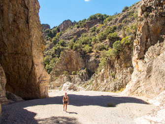 Flussbett des Riu Calaresu mit Steinen, Wasserlauf und grüner Schluchtenlandschaft auf Sardinien