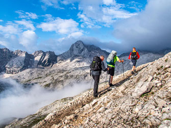 Drei Wanderer, darunter zwei mit Handicap, beim Aufstieg auf die Zugspitze im Wettersteingebirge