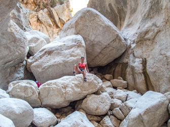 Enge Felswände der Gola di Gorropu mit Wanderern im steinigen Schluchtboden
