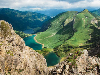 Allgäuer Alpen mit grünen Almwiesen, Bergen, Seen und Berghütte auf einer mehrtägigen Hüttentour