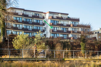Der grüne Pfeil kennzeichnet die Wohnung WELLENBLICK in der Anlage Residenz am Hang 9. Im Vordergrund die neu gestaltete Dünenmeile.