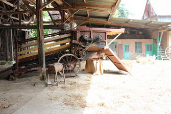 Vieille moissonneuse dans la cour de la ferme