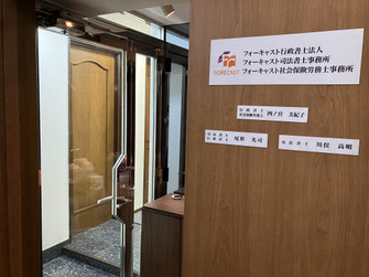 写真：事務所入口。壁にFORRCASTのロゴが飾られている