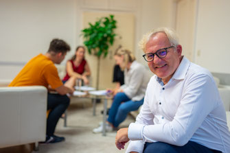 Martin Rotter mit Blick in die Kamera vor einer Teilnehmerinnen Gruppe