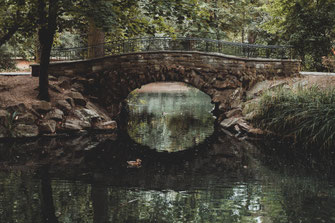 Einsame alte Steinbrücke über den Teich im Park