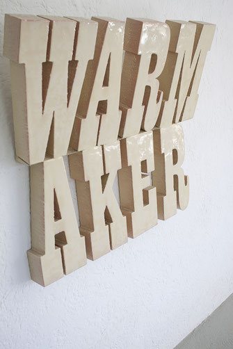 WARM AKER, WAR MAKER ist ein Kunstwerk, welches mit Buchstaben geschrieben von der Wand absteht. Die Schriftart erinnert an eine Bar im letzten Western. WARM steht oben, AKER darunter. Die Plastik ist in einem Hautton mit Epoxidharz überarbeitet.