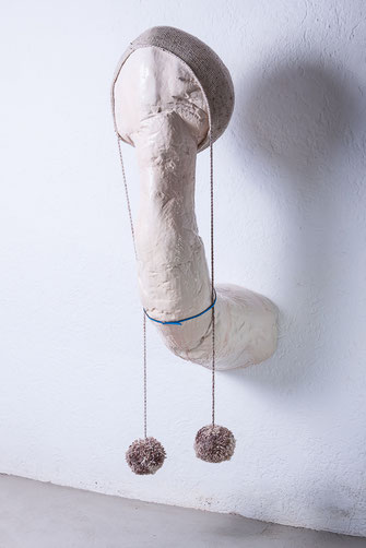 Arbeiten von Braig sind sehr vom Minimalismus geprägt. Mother's Darling ist ein figuratives Beispiel. Ein übergroßer Penis, mit einer Mütze mit zwei Wollpompons und einem blauen Gürtel, kommt aus der Wand. Farbe: Weißtöne. Das Verhältnis Mutter und Sohn. 