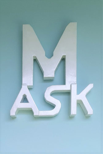 M/ASK 2021 von Oliver Braig. Ein Skulptur aus Buchstaben. Ein großes M und darunter ASK. Wer trägt welche Alltagsmasken? Warum tragen wir Masken? Wem zeige ich mich wie? Wieviel Makeup brauche ich, um mich wohl zu fühlen? Was verstecke ich hinter meiner A