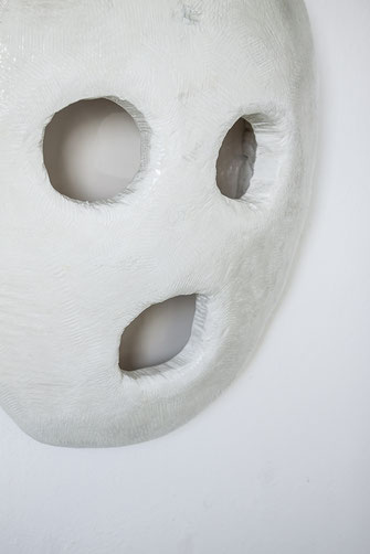 BREAHTER ein plastisches, weißes Gesicht aus Holz an der Wand wie eine Maske. Die Augen, wie auch der Mund sind Löcher. Das Gesicht hat keine Nase. Entlüftung oder Vakuumierung? Stummer Schrei oder erstarrend im Schock? Braig stellt immer wiederFragen.