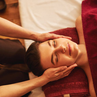Frau erhält eine entspannende Gesichts- und Kopfmassage