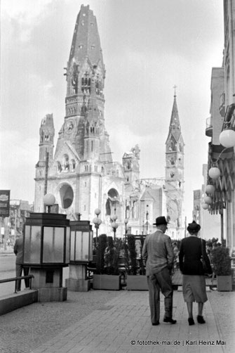 Zerstörte Berliner Kirche, intakte Ladenstraße und Passanten in Berlin