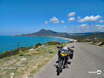 Italien mit dem Motorrad, Sardinien, BMW F800GS steht am Strassenrand und dahiner sieht man Meer, Strand und Berge