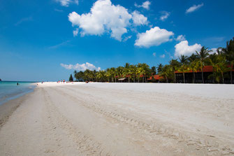 Weisser Sand und weitlaufiger Strand mit Palmen und Bungalows auf Langkawi Cenang