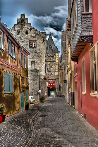 Gasse in Bacharach mit Blick auf die Stadtmauer und den Turm im Hintergrund