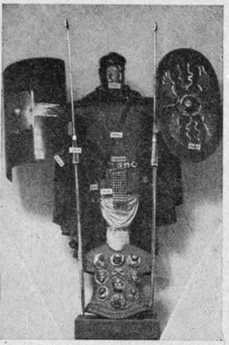 Trophäe aus röm. Waffen (Schilde, Pilen, unten Lederkoller mit Ehrenzeichen).