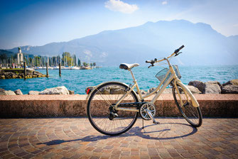 Ein Fahrrad steht am Ufer vor einem Gardasee