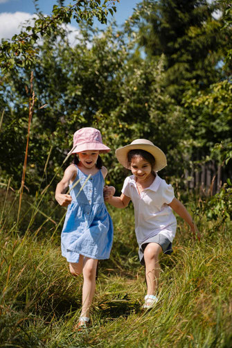 Kinder laufen in grüner Wiese