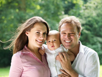 Junges Paar mit Baby informiert sich über CosmosDirekt Risikolebensversicherung, um die Familie im Todesfall finanziell abzusichern