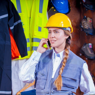 jeune femme avec casque jaune au téléphone, au travail 