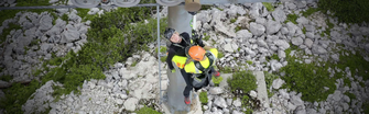 Eine Person hat eine andere bewusstlose Person gesichert und seilt mit ihr Richtung Boden ab