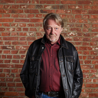 Dietmar Wischmeyer vor einer Ziegelwand
