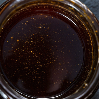 Photo d'un pot de Miellat de Miel de Manuka très sombre et liquide de Nouvelle-Zélande