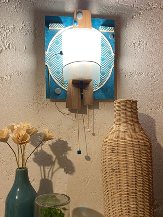 Applique murale bleu avec bois, laiton et tissus graphique. Un luminaire d'artisanat d'art par Isabelle Lachat créations à Rumilly vers Annecy et Haute Savoie.