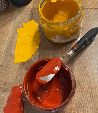 Bild von zwei Gläsern mit selbst angemischter Linoldruckfarbe rotbraun und dunkelgelb