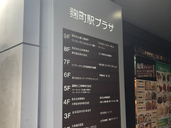 写真：ビルの入口。麹町駅プラザの名称とフロアガイド