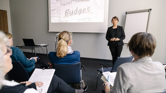 Gesprächsrunde auf einer Bühne mit vier Frauen bei einem Führungskräfte-Workshop - interaktive Formate zur Entwicklung von Führungskompetenz.